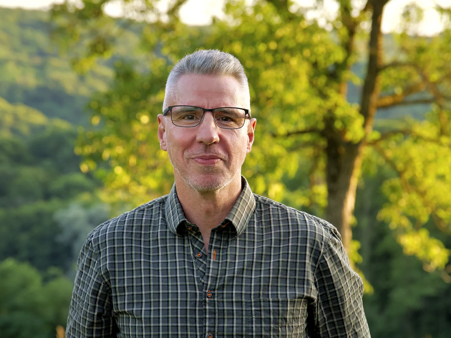 Carsten Raukohl, Gründer von JAGD TOTAL, im Freien vor bewaldeten Hügeln